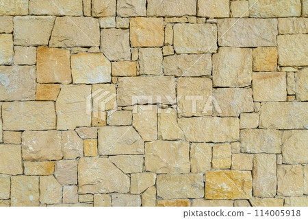 real stone wall made of yellow stone 114005918