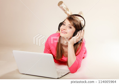 Girl with headphones and laptop listening to music 114005964