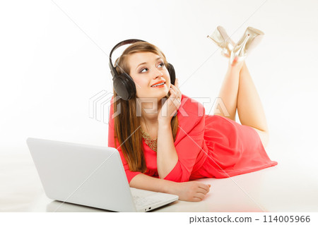 Girl with headphones and computer listening to music 114005966