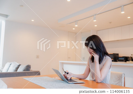 A busy woman eating while working remotely A busy woman eating while working remotely 114006135
