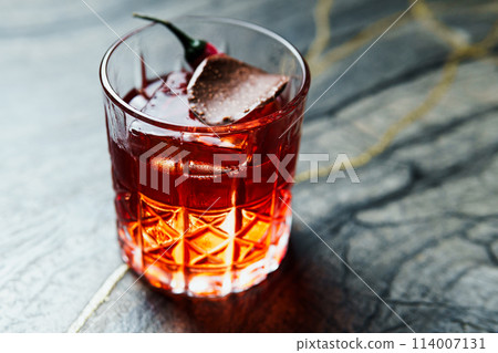 Alcoholic drink. A cocktail with elite alcohol on dark black background Alcoholic drink. A cocktail with elite alcohol on dark black background 114007131