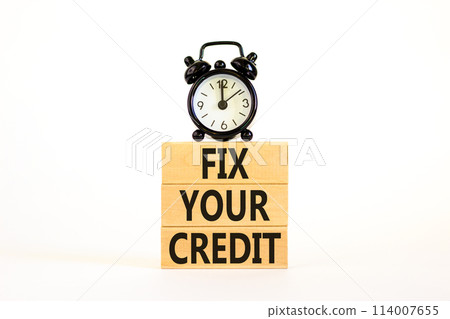 Fix your credit symbol. Concept words Fix your credit on wooden blocks on a beautiful white table white background. Black alarm clock. Business, finacial and fix your credit concept. Copy space. 114007655