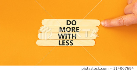 Do more with less symbol. Concept word Do more with less on beautiful beautiful wooden stick. Beautiful orange table orange background. Businessman hand. Business do more with less concept. Copy space Do more with less symbol. Concept word Do more with less on beautiful beautiful wooden stick. Beautiful orange table orange background. Businessman hand. Business do more with less concept. Copy space 114007694