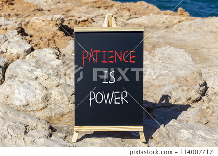 Patience is power symbol. Concept words Patience is power on beautiful black chalk blackboard. Beautiful red stone blue sea background. Business and patience is power concept. Copy space. 114007717