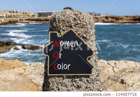 WOC women of color symbol. Concept words WOC women of color on beautiful yellow blackboard. Beautiful stone blue sky sea background. Business WOC women of color social issues concept. Copy space. WOC women of color symbol. Concept words WOC women of color on beautiful yellow blackboard. Beautiful stone blue sky sea background. Business WOC women of color social issues concept. Copy space. 114007718