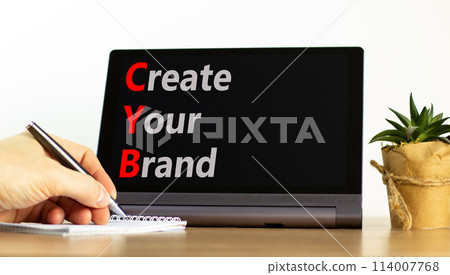 CYB Create your brand symbol. Concept words CYB Create your brand on beautiful black tablet. Beautiful white background. Businessman hand. Business CYB Create your brand concept. Copy space. 114007768