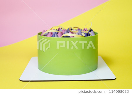Close-up of mousse cake decorated with chocolate tulip, close up, yellow and pink background Close-up of mousse cake decorated with chocolate tulip, close up, yellow and pink background 114008023
