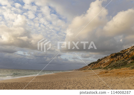 A beach with a cloudy sky in the background A beach with a cloudy sky in the background 114008287