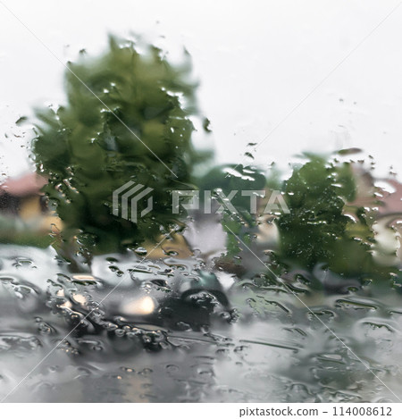 Blurred view of road through wet car window Blurred view of road through wet car window 114008612