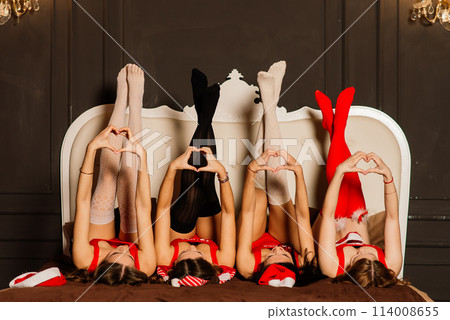 Four pretty women with curly hair and red Christmas lingerie. New year background. 114008655