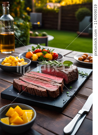 Steak on the table or on the grill in the backyard of a house or villa on a weekend or vacation. Sunny day, close-up Steak on the table or on the grill in the backyard of a house or villa on a weekend or vacation. Sunny day, close-up 114009019