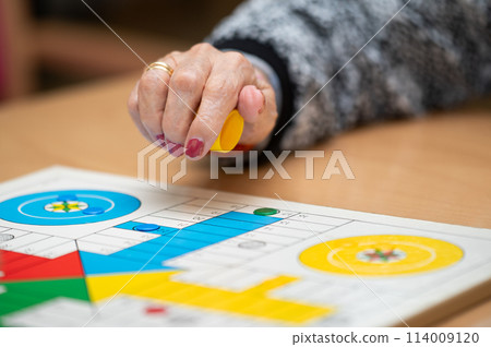 Group of unrecognizable senior woman playing the classic game Ludo or Parchis at nursing home. Group of unrecognizable senior woman playing the classic game Ludo or Parchis at nursing home. 114009120