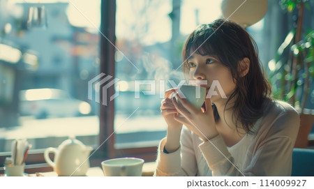 一位女士在靠窗的座位上喝咖啡 114009927