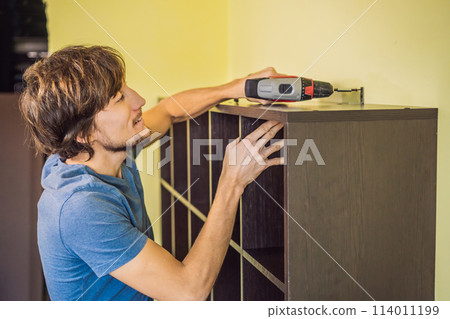 Frustrated Man Putting Together Self Assembly Furniture 114011199