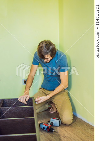 Frustrated Man Putting Together Self Assembly Furniture Frustrated Man Putting Together Self Assembly Furniture 114011221