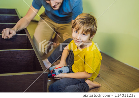Father and son assembling furniture. Boy helping his dad at home. Happy Family concept Father and son assembling furniture. Boy helping his dad at home. Happy Family concept 114011232