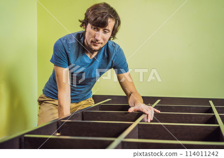 Frustrated Man Putting Together Self Assembly Furniture Frustrated Man Putting Together Self Assembly Furniture 114011242