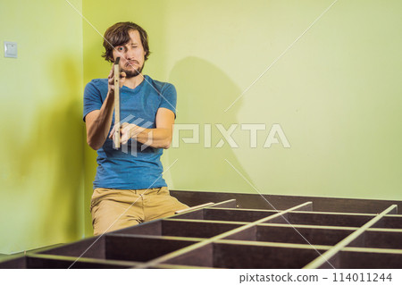Frustrated Man Putting Together Self Assembly Furniture 114011244