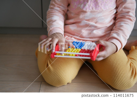 toddler playing with counting math learning toy . toddler playing with counting math learning toy . 114011675