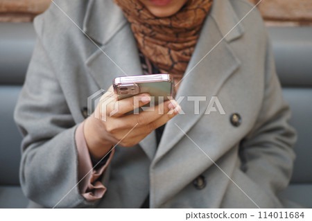 women hand holding smart phone sitting on cafe women hand holding smart phone sitting on cafe 114011684