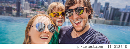 Vacation and technology. Happy family with kid taking selfie together near swimming pool with panoramic views of the city BANNER, LONG FORMAT 114012848