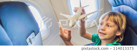 Little boy play with toy plane in the commercial jet airplane flying on vacation BANNER, LONG FORMAT Little boy play with toy plane in the commercial jet airplane flying on vacation BANNER, LONG FORMAT 114013373
