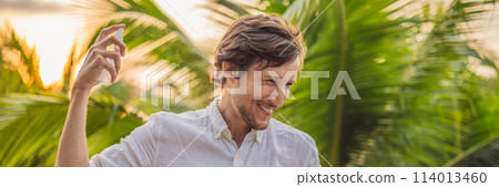 Young man spraying mosquito insect repellent in the forrest, insect protection BANNER, LONG FORMAT 114013460