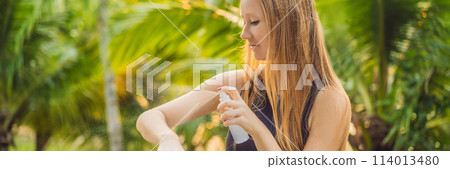 Woman spraying insect repellent on skin outdoor BANNER, LONG FORMAT 114013480