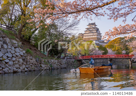 Himeji Castle and cherry blossoms in Himeji, Hyogo Prefecture. A boatman packing up his Japanese boat after a day of business. 114013486