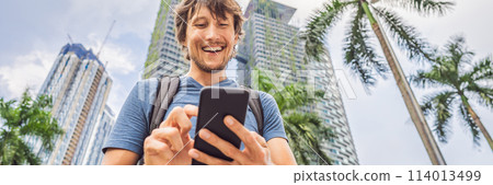 Man Tourist using navigation app on the mobile phone. Navigation map on a smartphone in a big city BANNER, LONG FORMAT 114013499