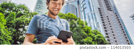 Man Tourist using navigation app on the mobile phone. Navigation map on a smartphone in a big city BANNER, LONG FORMAT Man Tourist using navigation app on the mobile phone. Navigation map on a smartphone in a big city BANNER, LONG FORMAT 114013503