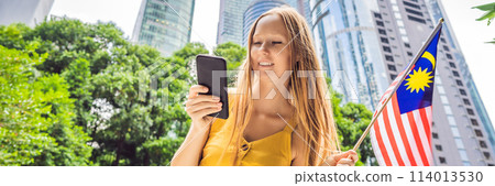 Travel and technology. Young woman tourist with the flag of Malaysia is looking at a city map in a smartphone for navigation BANNER, LONG FORMAT Travel and technology. Young woman tourist with the flag of Malaysia is looking at a city map in a smartphone for navigation BANNER, LONG FORMAT 114013530