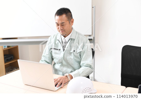 一名中年男性工人在電腦上工作 114013970