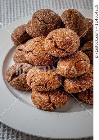 Warm Homemade Gingersnap Cookies on a light background in a plate Warm Homemade Gingersnap Cookies on a light background in a plate 114014219