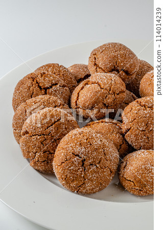 Warm Homemade Gingersnap Cookies on a light background in a plate Warm Homemade Gingersnap Cookies on a light background in a plate 114014239