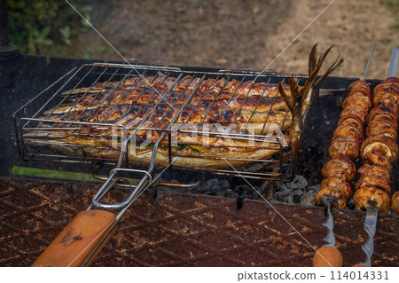 Grilled fish. Cooking fish on the barbecue grid. Grilled fish. Cooking fish on the barbecue grid. 114014331