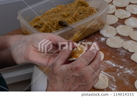Woman hands are making a damp dumpling. . 114014333