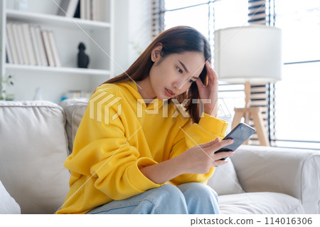 Bad news on device screen. Upset asian woman frustrated by problem with work or relationships Bad news on device screen. Upset asian woman frustrated by problem with work or relationships 114016306