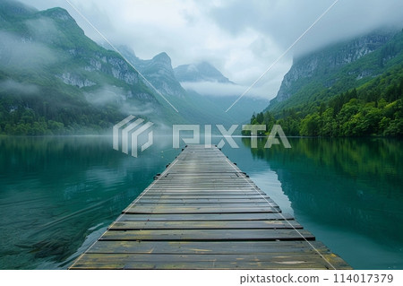 Peaceful lake bordered by a humble wooden pier, with serene mountains rising in the background Peaceful lake bordered by a humble wooden pier, with serene mountains rising in the background 114017379