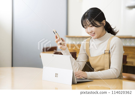 在她的智能手機上網上購物的年輕女人 在她的智能手機上網上購物的年輕女人 114020362