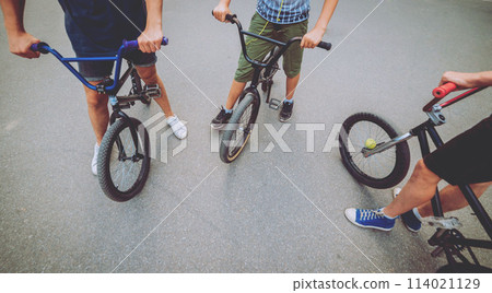 Company of young people on BMX. Beautiful background. Company of young people on BMX. Beautiful background. 114021129