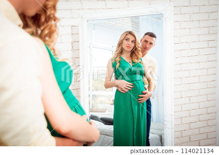 Young pregnant woman near a window. Background 114021134