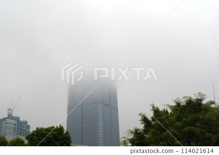 A skyscraper with its head hidden by cloudy skies 114021614