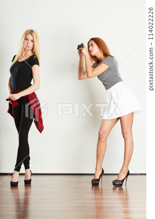 Mulatto girl photographing blonde woman Mulatto girl photographing blonde woman 114022226