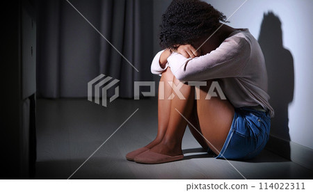 Depressed African Woman Sitting Alone on the Floor in a Dark Room - Generative Ai 114022311