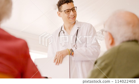 Gay doctor writing data in a medical report of senior people Gay doctor writing data in a medical report of senior people 114022408