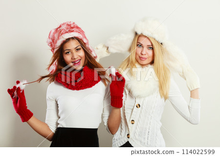 Two smiling girls in warm winter clothing. 114022599