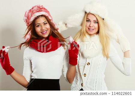 Two smiling girls in warm winter clothing. Two smiling girls in warm winter clothing. 114022601
