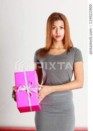 Beautiful mulatto woman with pink gift. 114022900