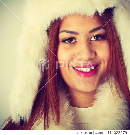 Mulatto woman wearing winter fur cap 114022979